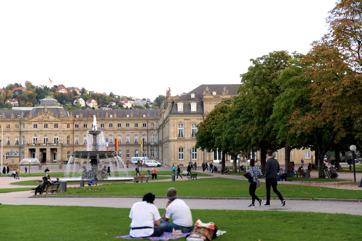 Menschen im Park vor dem neuen Schloss Stuttgart bei mildem Licht – idealer Ort fuer ruhige Begegnungen mit Escort Stuttgart