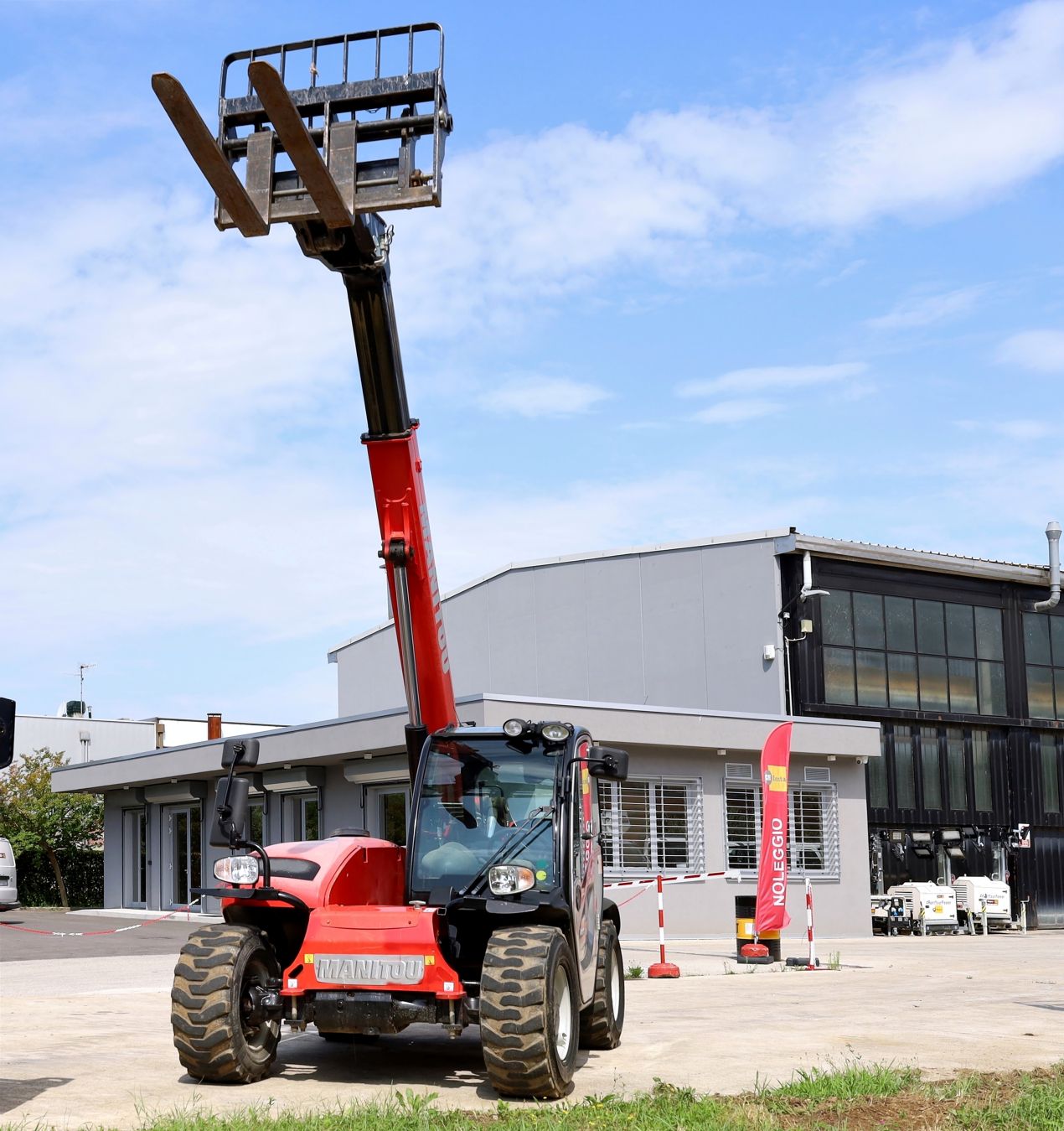 Roter Teleskopstapler mit ausgefahrenem Hubarm vor Industriegebäude – ideal für kurzfristige Einsätze, Teleskopstapler mieten als flexible Lösung