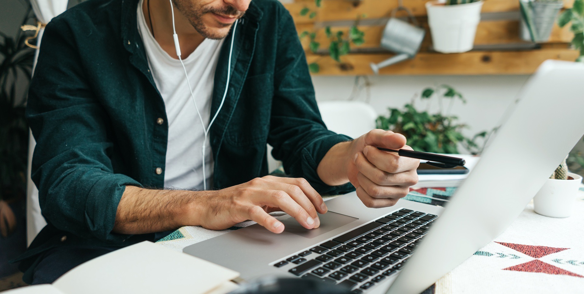 Mann arbeitet konzentriert am Laptop mit Kopfhörern | Schrankbett